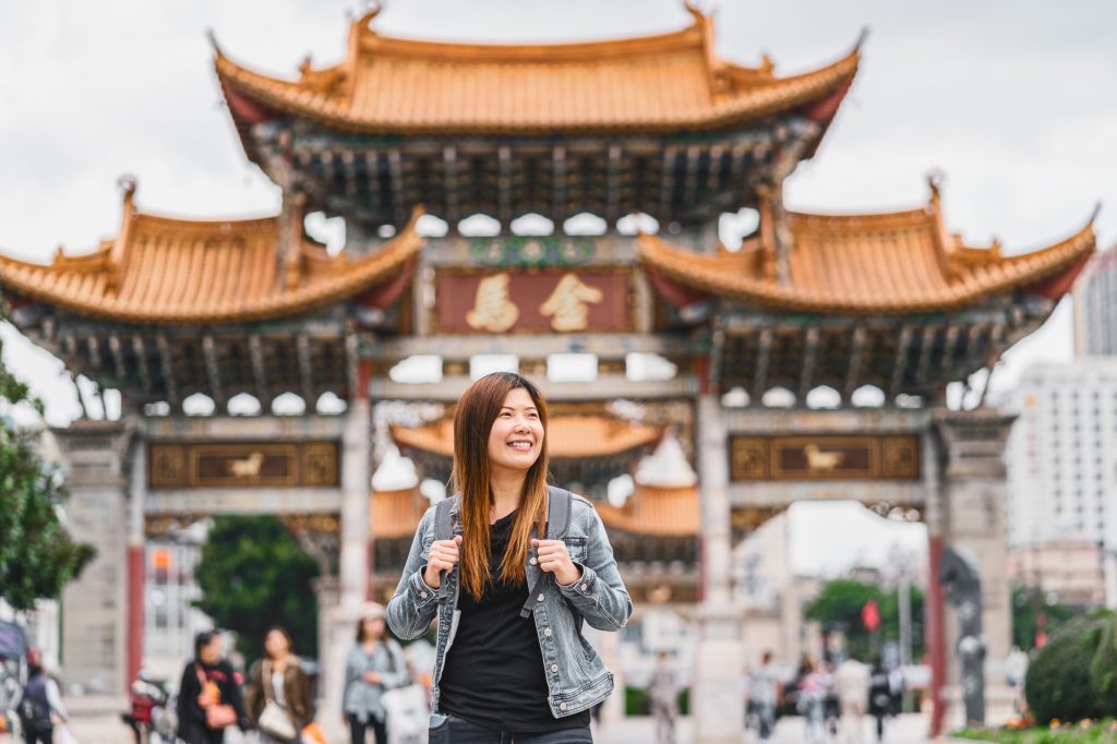 Asian traveler woman looking and sightseeing when travelling over the Jinbi square, Kunming, China