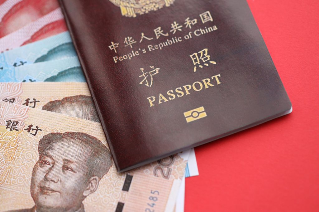 Red passport of People Republic of China and chinese yuan money bills. PRC chinese passport